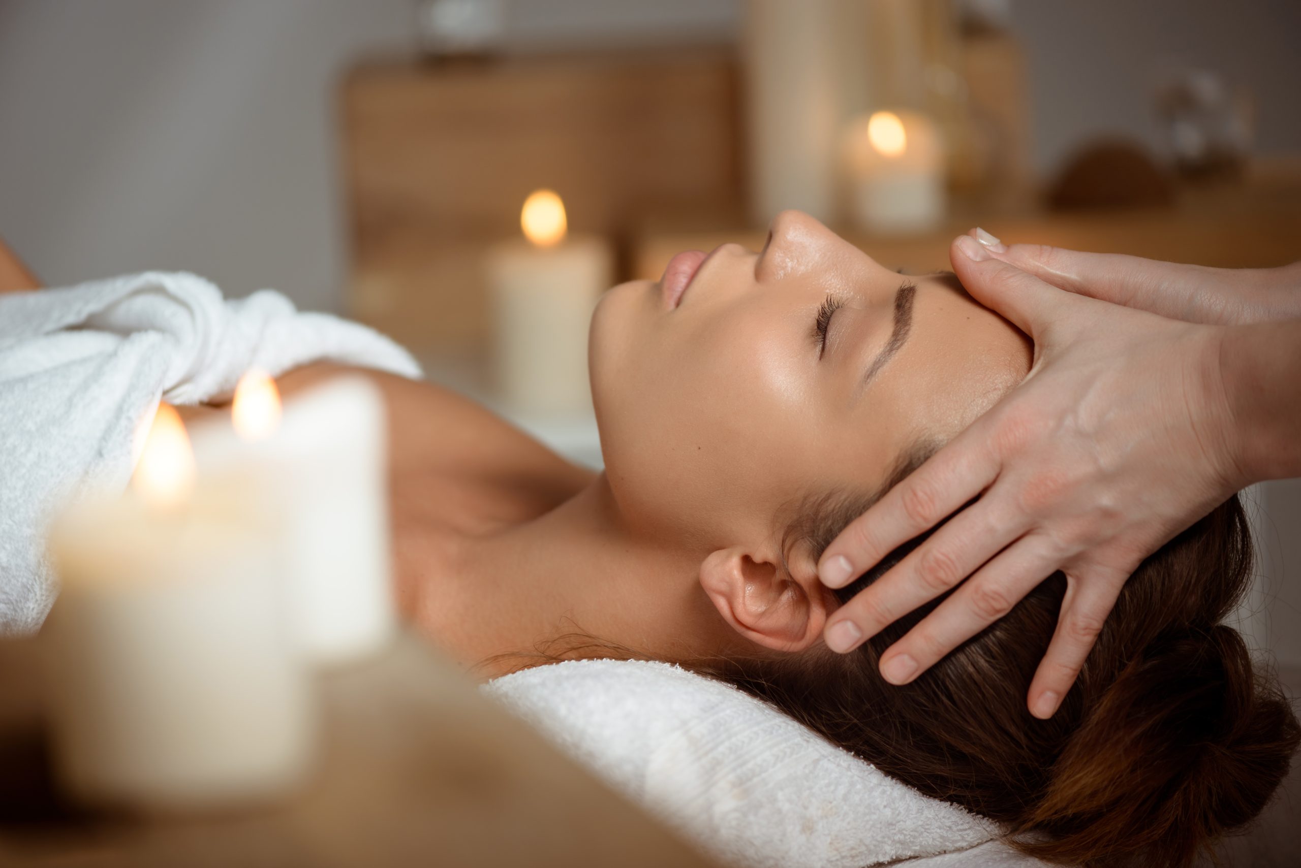 young beautiful girl having face massage relaxing in spa salon.